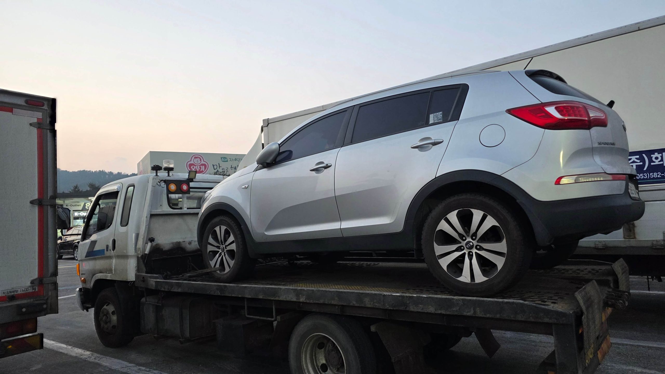 manual car being towed on a highway tow truck after a breakdown