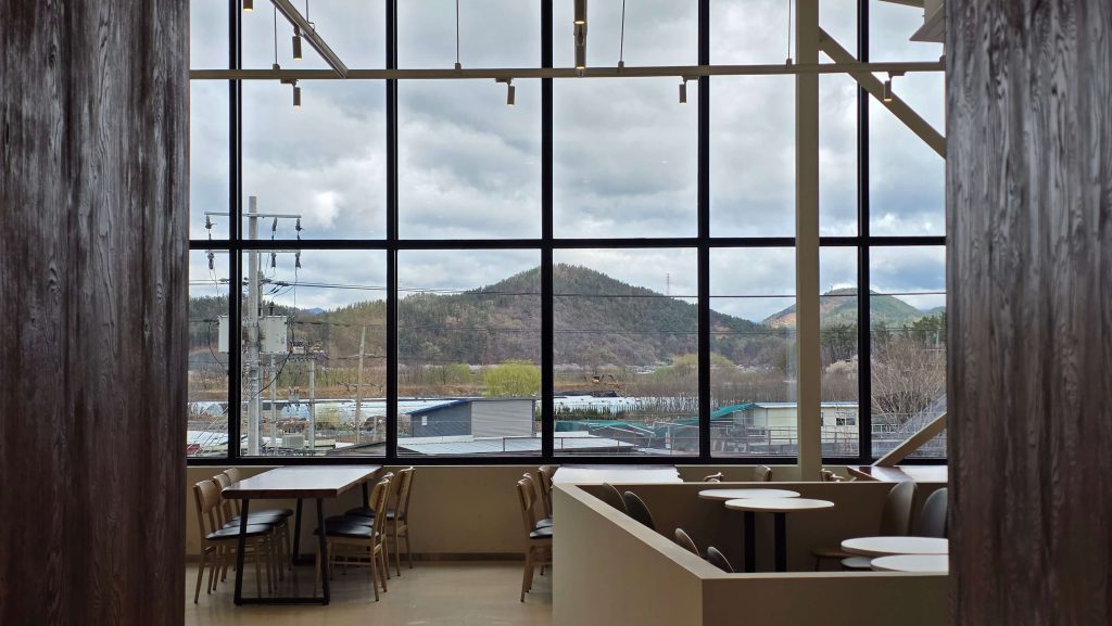 view through large cafe window with mountains and cloudy sky after rain