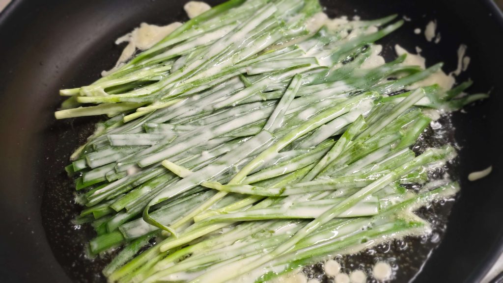 cooking buchujeon with senses while adjusting batter and balance in a pan