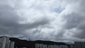 overcast sky above quiet apartment buildings and distant hills