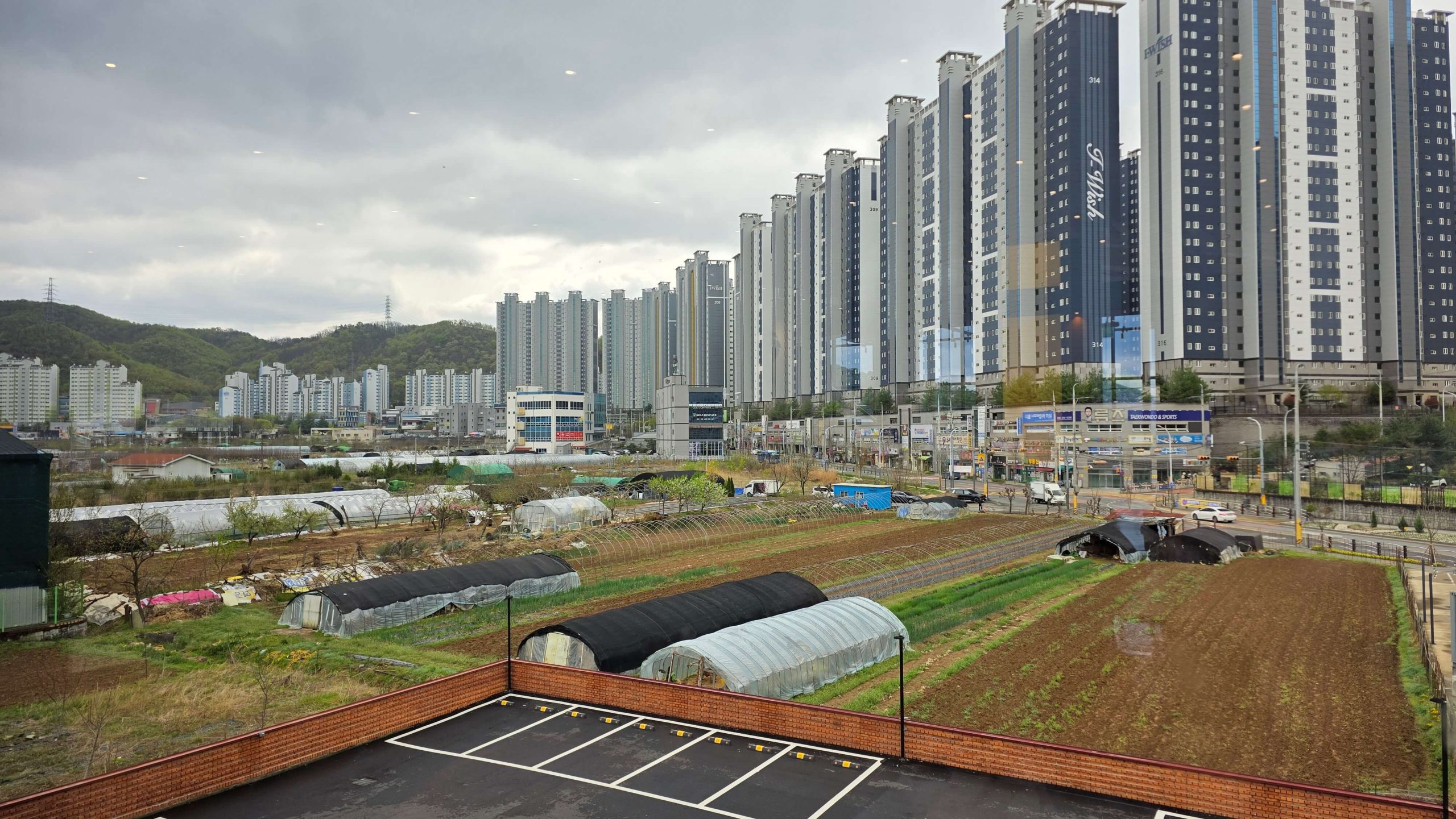 view from a quiet cafe corner showing fields and apartment buildings in contrast