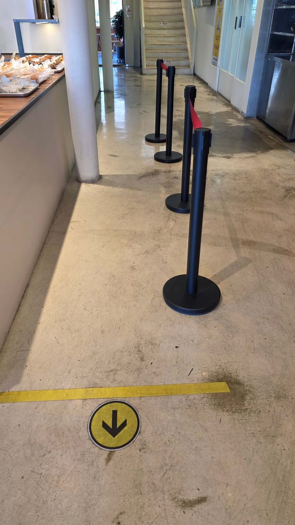 An awkward waiting line inside a quiet café, showing how a simple space can quietly pull people into thinking mode.