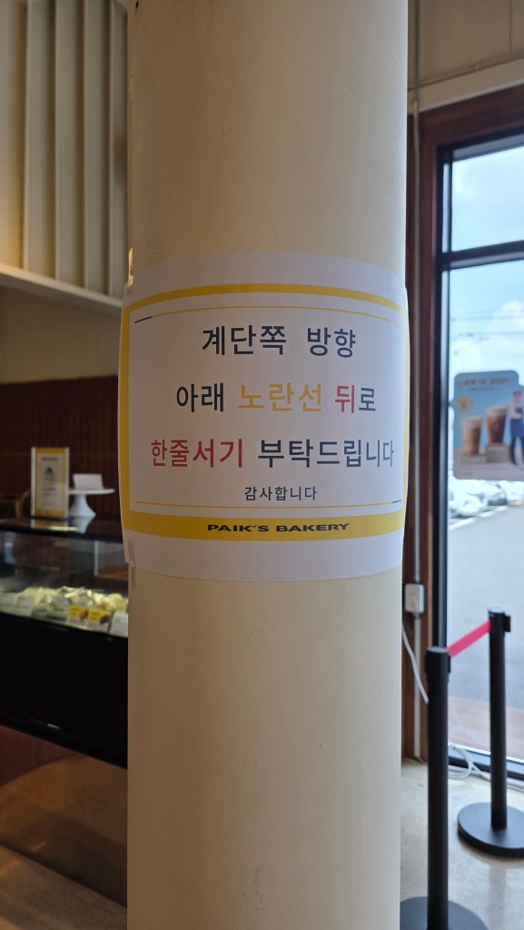 Additional sign placed on a pillar directing customers where to wait