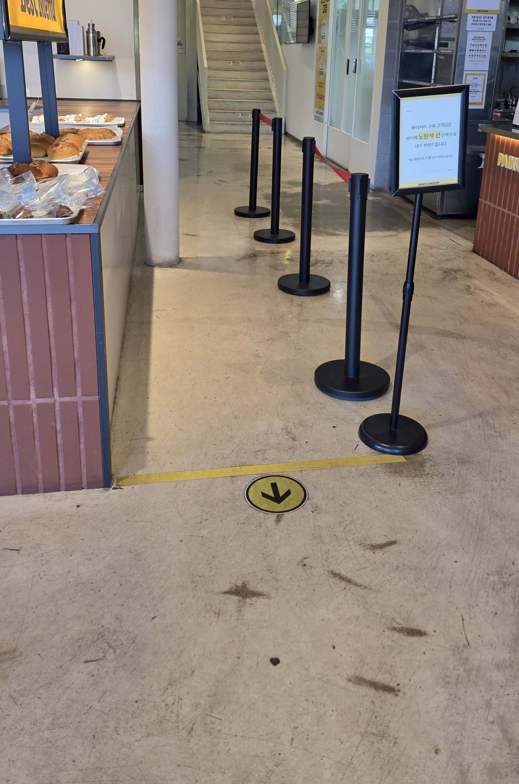 A yellow arrow and waiting line inside a quiet café, showing the moment a simple café layout led into thinking mode.