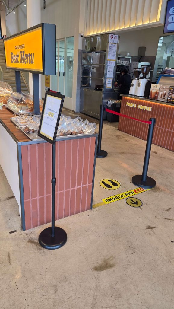 Sign and footprint markers showing where customers should wait in line