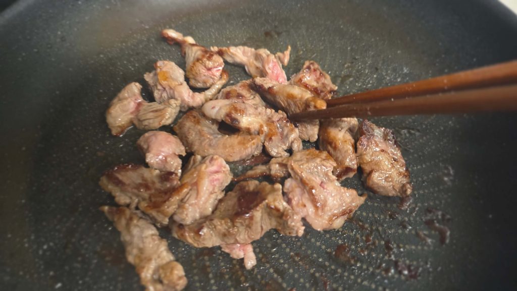 Grilling beef one piece at a time while preparing lunch