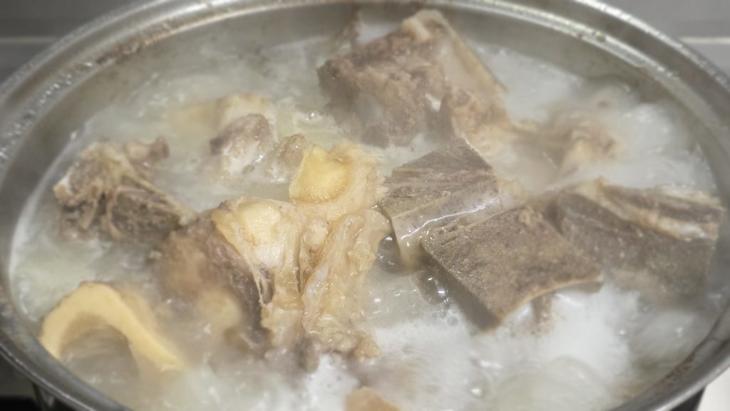 A pot of homemade bone broth simmering on the stove