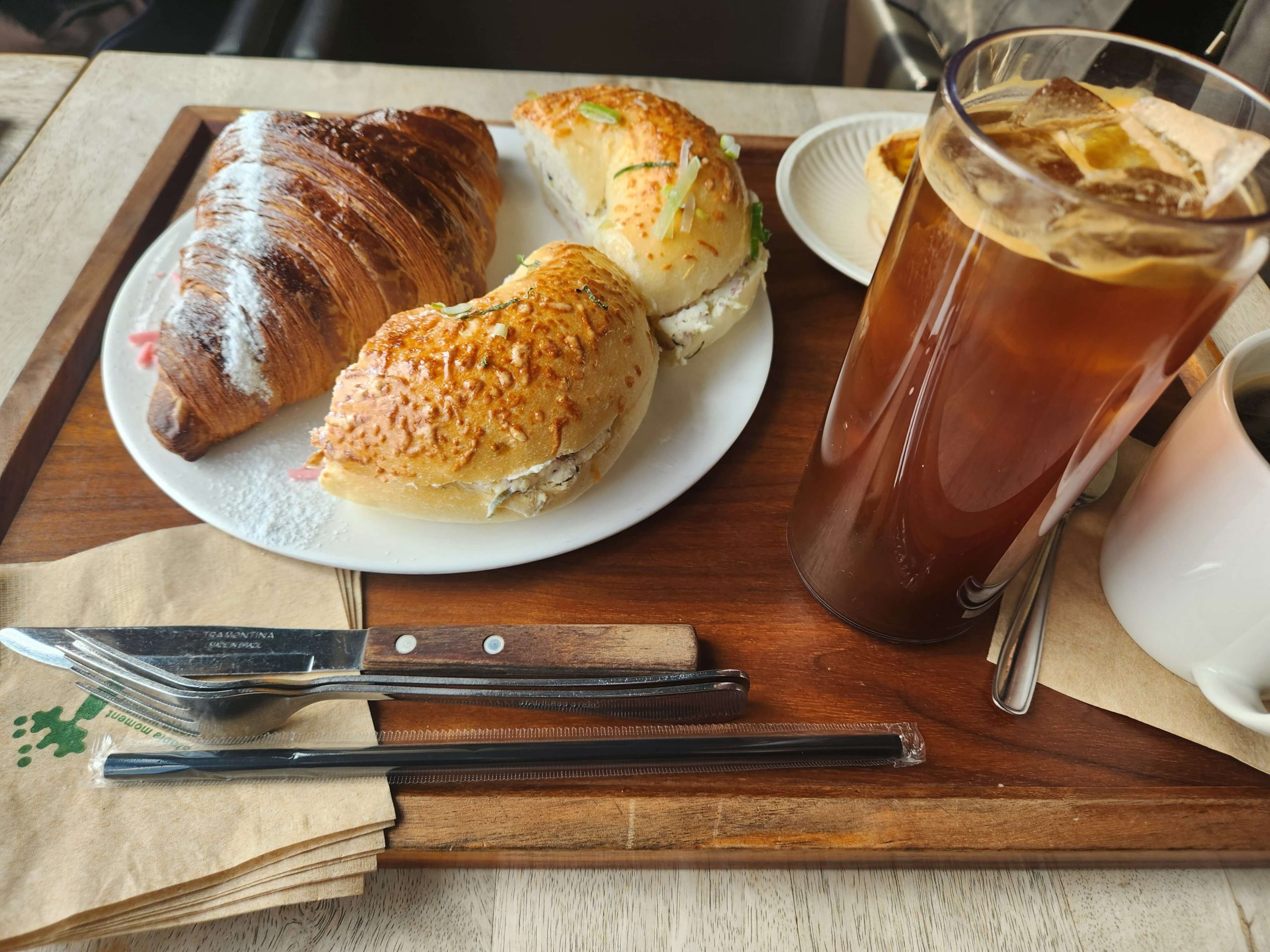 A croissant, cream cheese bagels, and coffee at a café, reflecting on taking things for granted in everyday life.