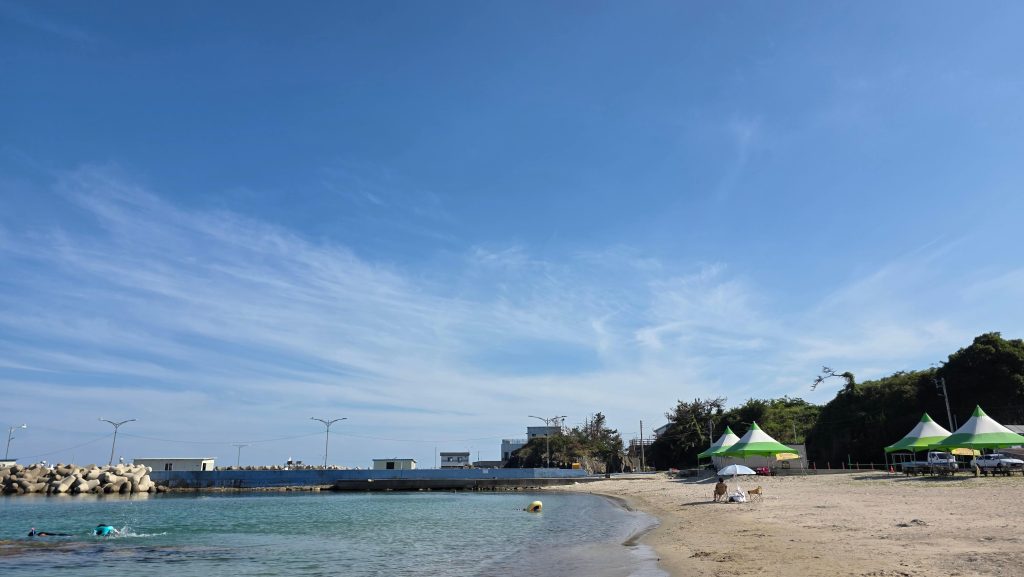 People enjoying the sea in different ways on a quiet summer beach in Korea.