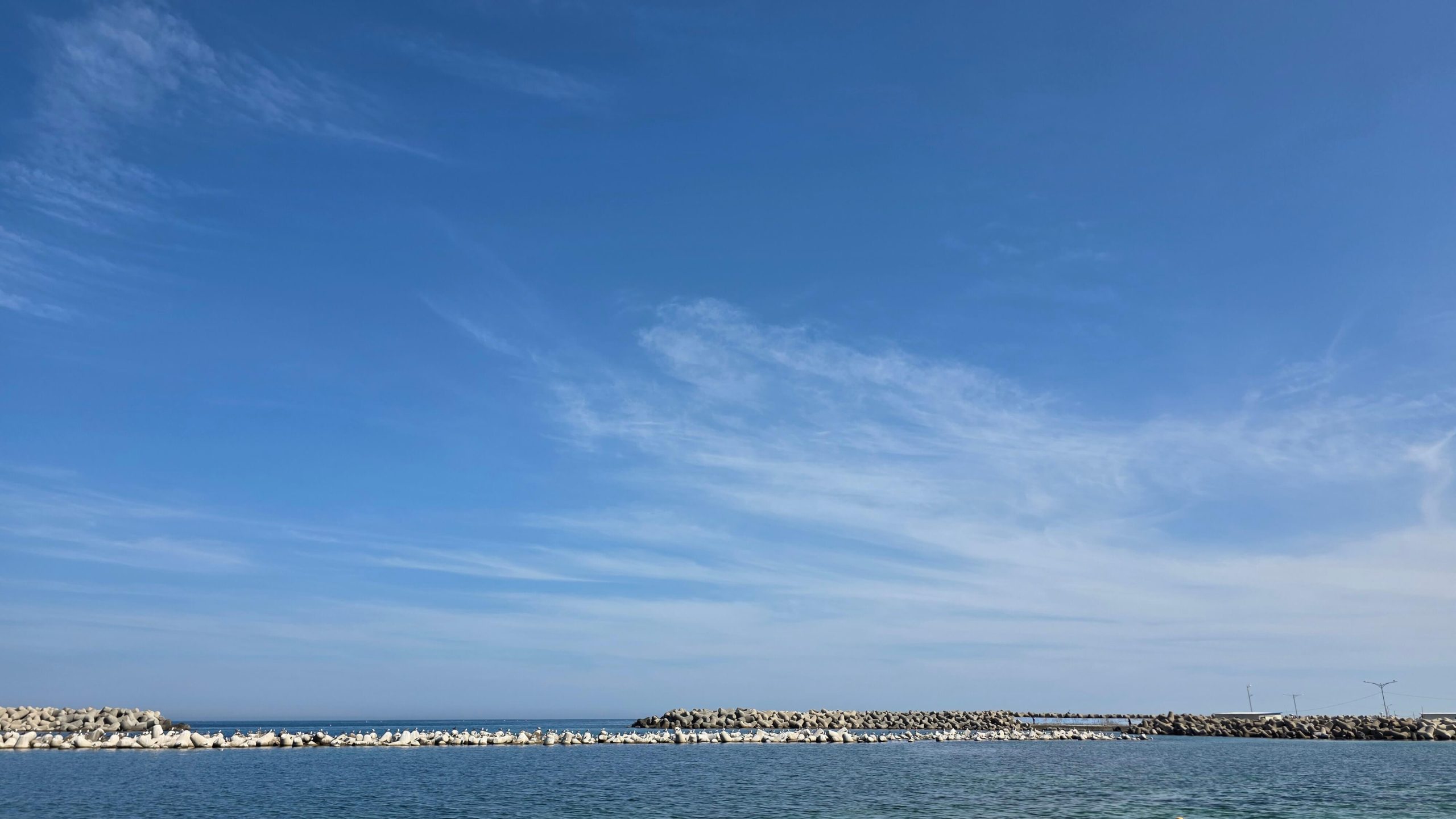 A quiet summer beach under a wide blue sky, where simply being there felt enough.