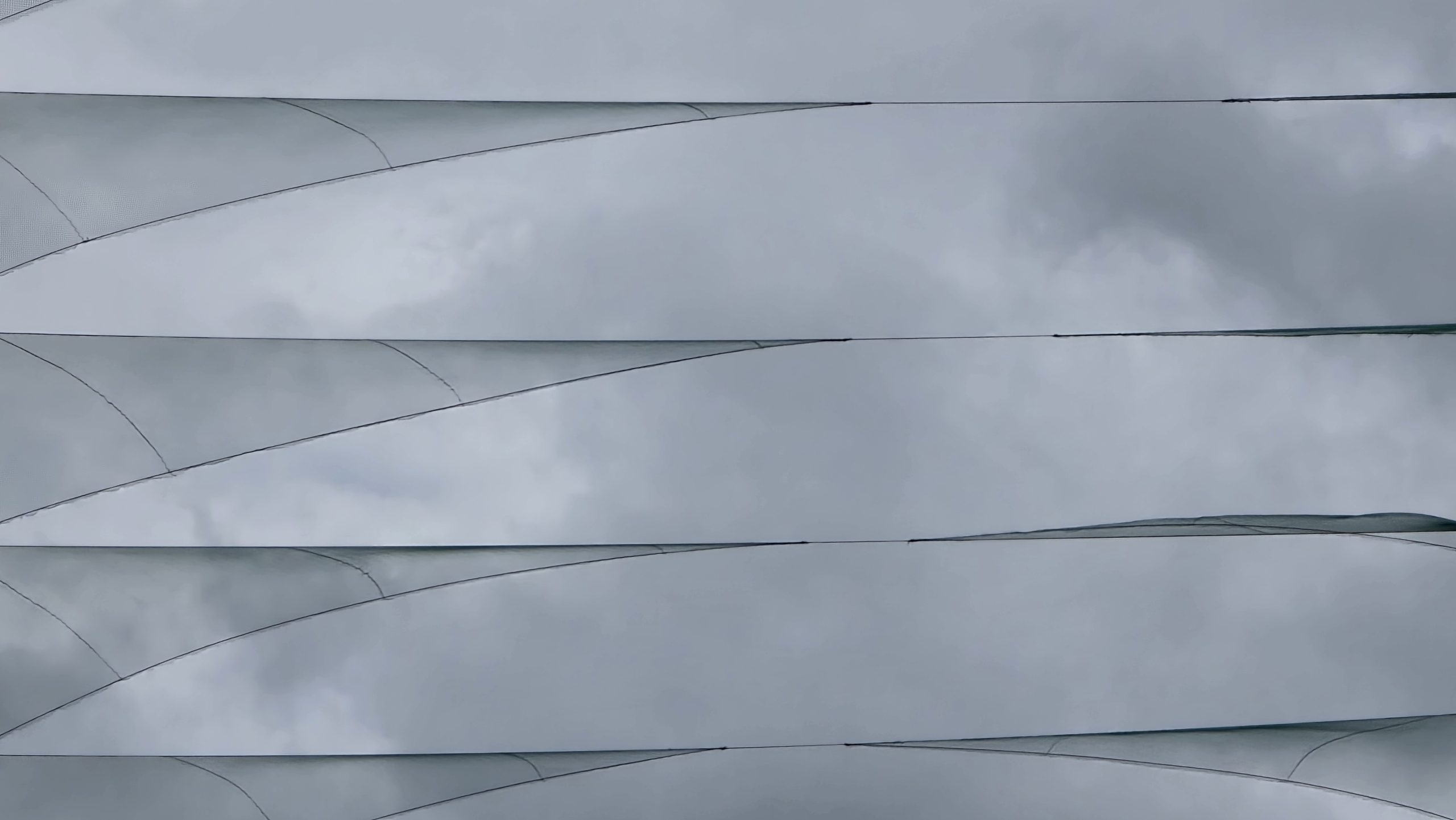 A cloudy sky seen through overlapping canopy panels, with parts of the sky hidden from view.