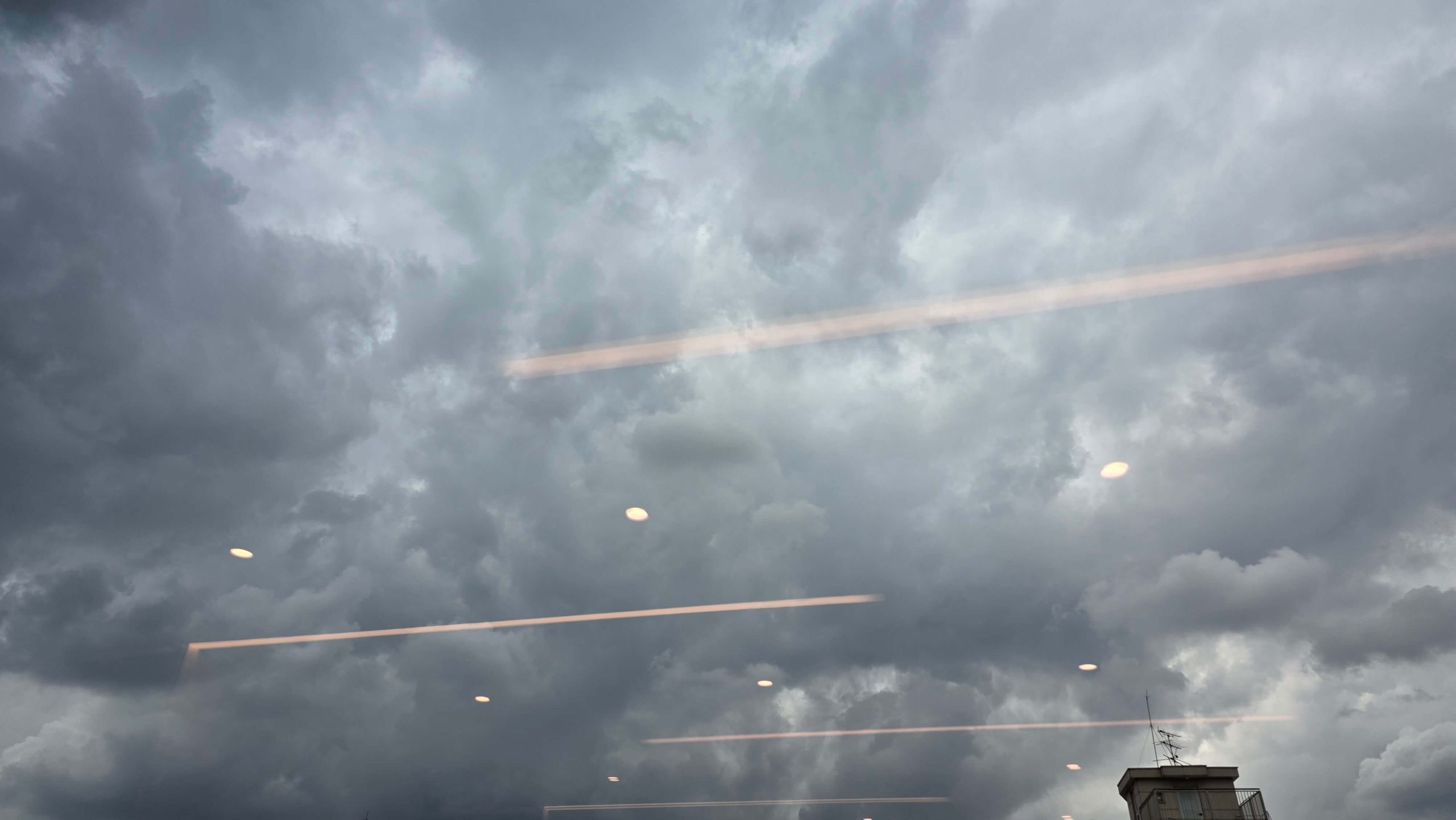 Storm clouds seen through a clinic window, reflecting the quiet pressure to get it right before knowing the truth.