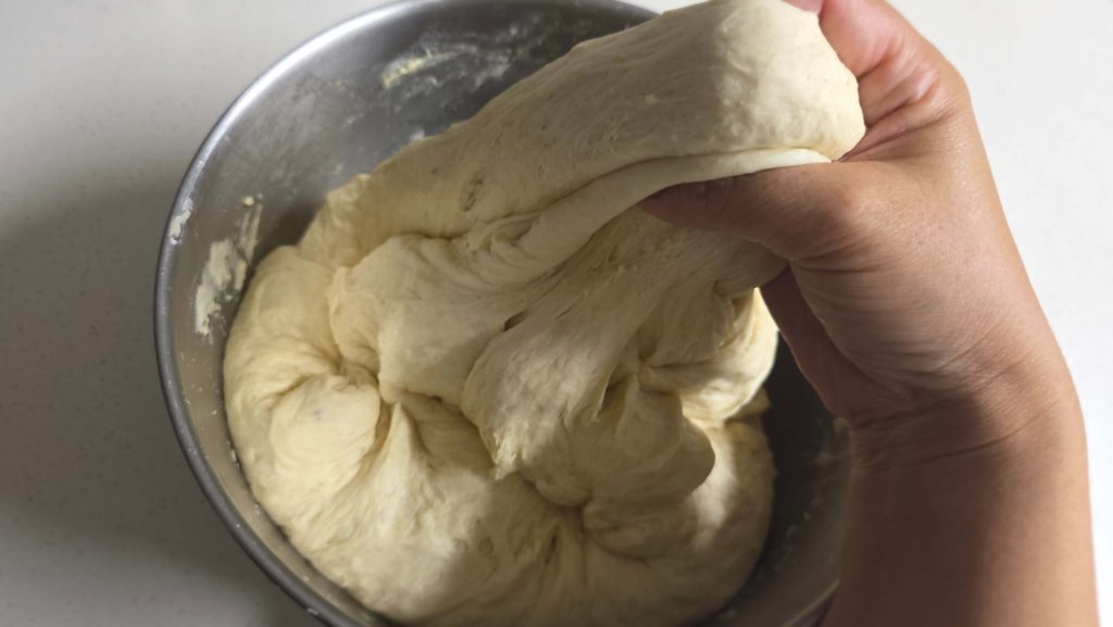 Stretching soft bread dough by hand