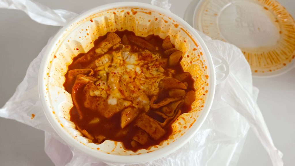 Delivered tteokbokki topped with melted cheese