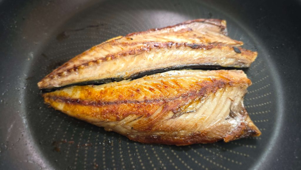 A whole grilled mackerel in a frying pan