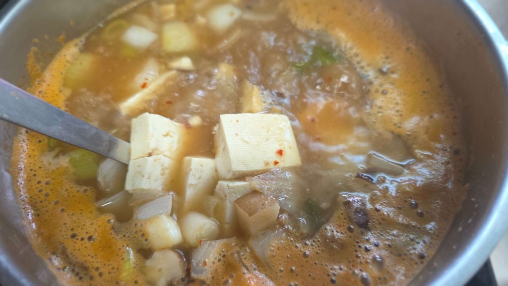 Homemade soybean paste soup with tofu simmering in a pot