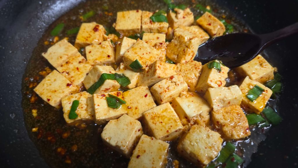 Braised tofu cooking in a frying pan