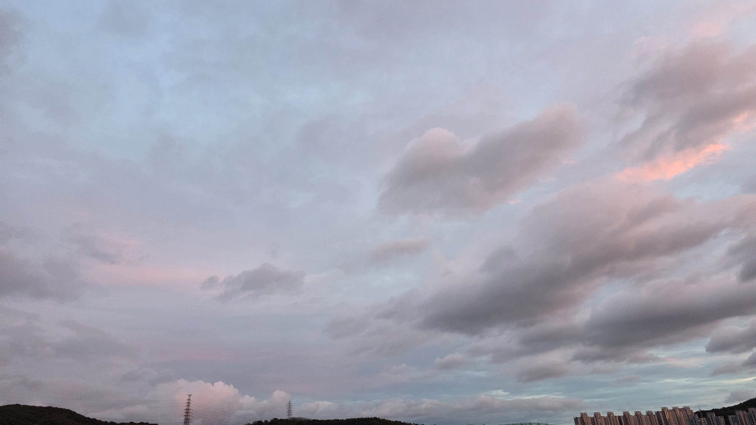 Soft pink clouds moving across an evening sky, reflecting the quiet rhythm of writing over time.
