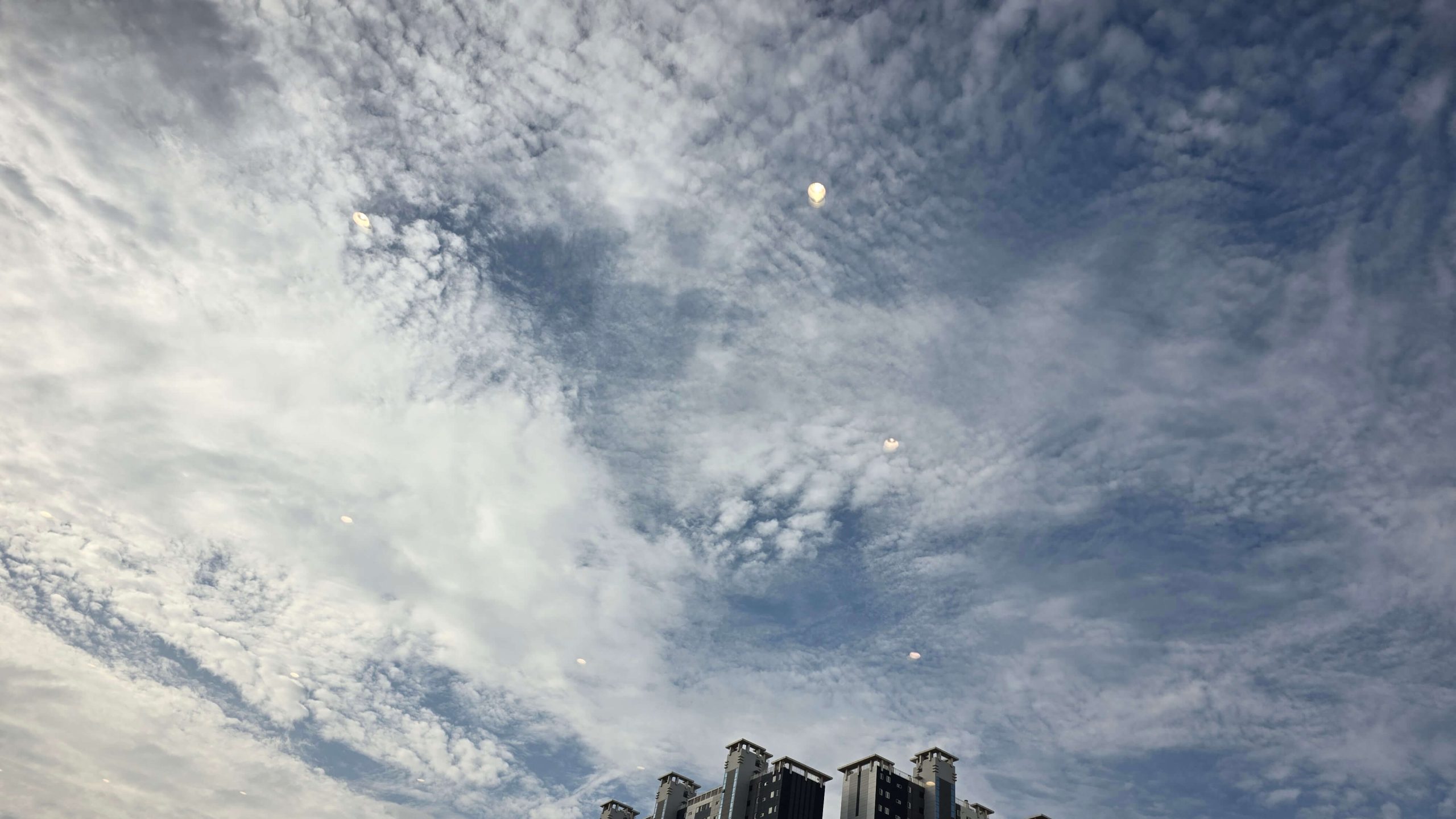 Cloud-filled blue sky seen through a cafe window