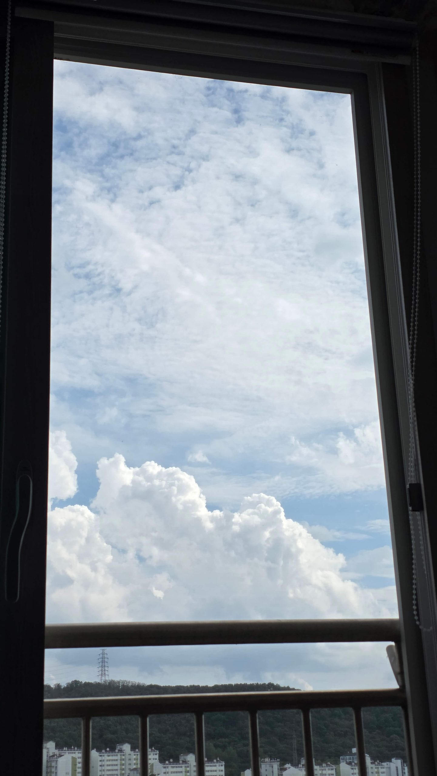 View of clouds through the window while lying down