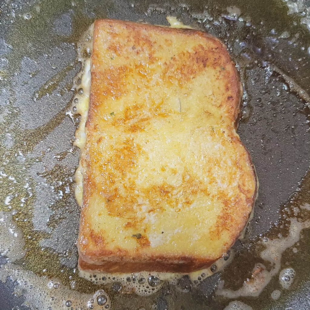 French toast cooking in butter in a frying pan