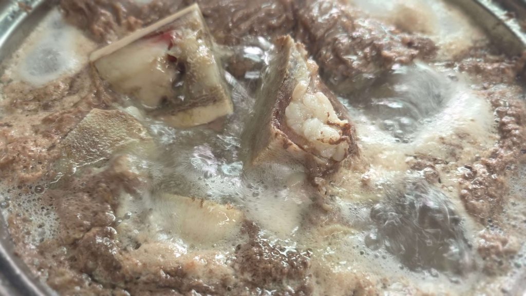 Beef bones and brisket boiling in a pot of gomguk