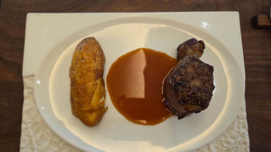 Lamb chop steak with mashed potatoes and brown sauce on a white plate