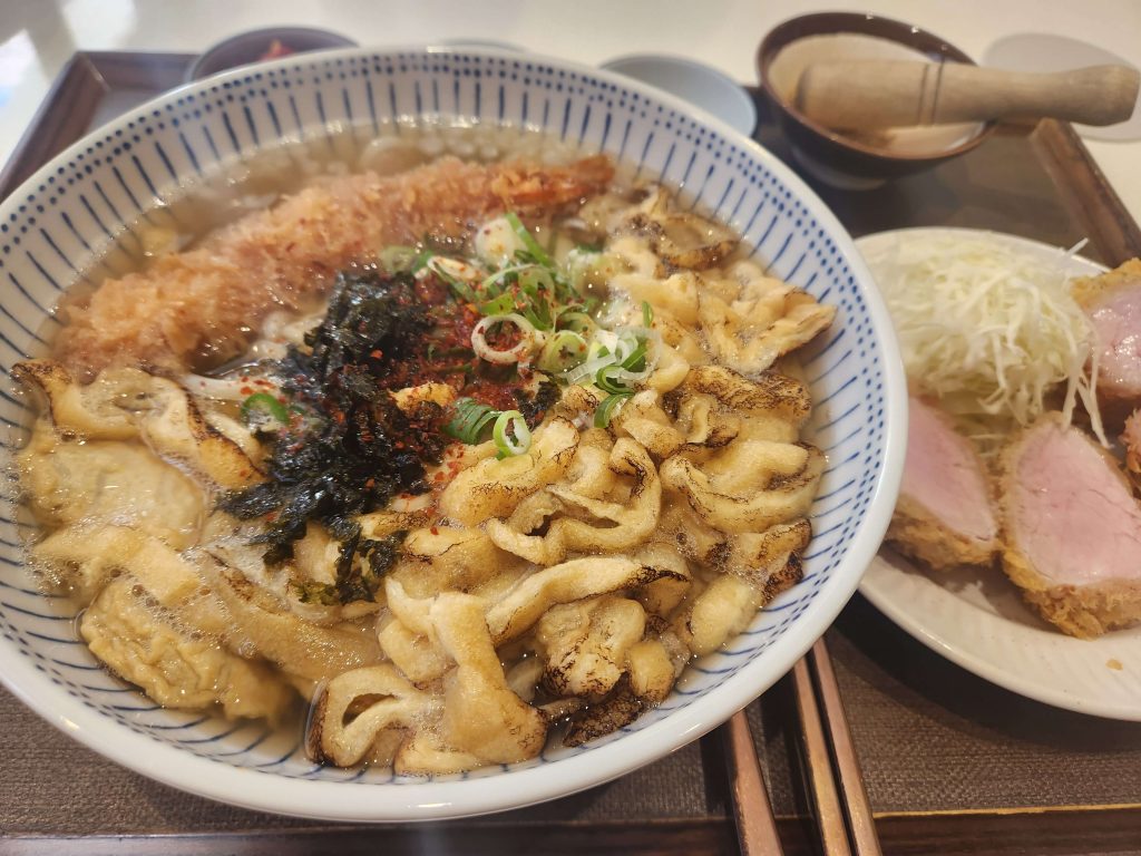 A Japanese restaurant meal with udon noodles and thick-cut pork tenderloin tonkatsu.