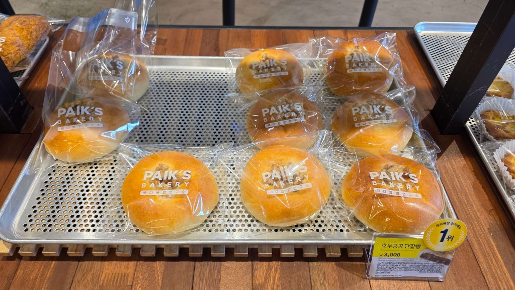 Individually wrapped sweet red-bean buns arranged on a bakery display tray.