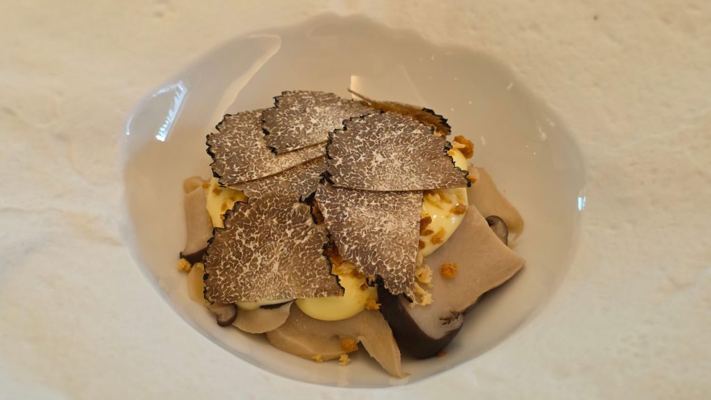 Truffle sformato topped with shaved truffles and served with mushrooms